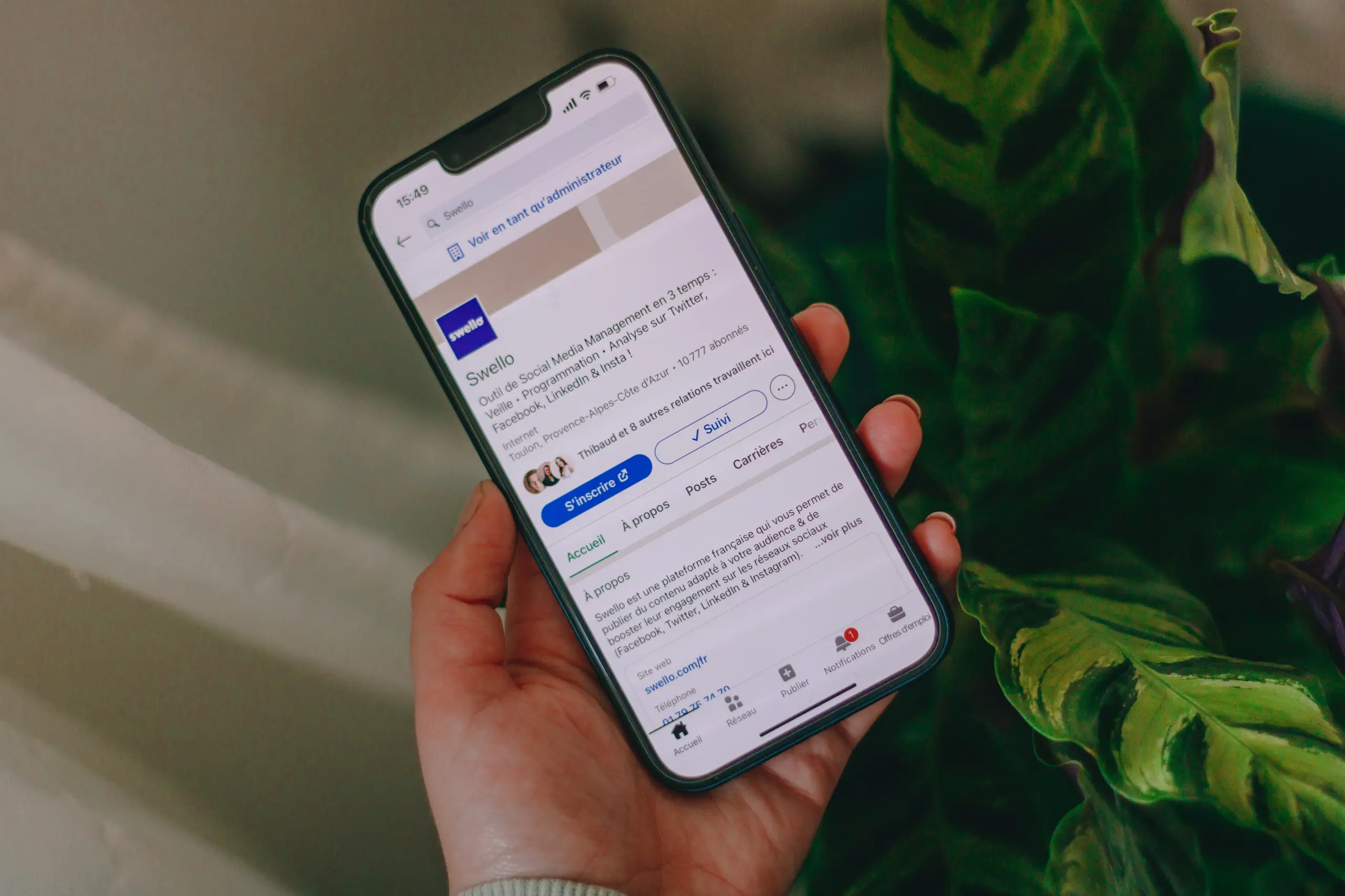 Photo of a hand holding an iPhone with the LinkedIn app open